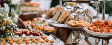 A wedding reception showcasing alternative catering options with a casual and relaxed setup, encouraging guests to mingle and enjoy various food stations or buffet-style arrangements, creating a cost-effective and inviting atmosphere.