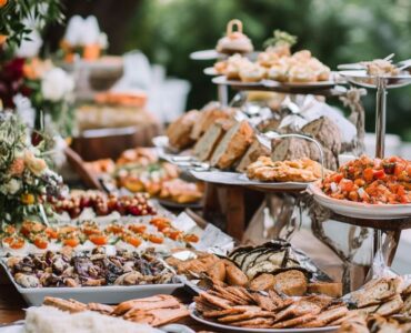 A wedding reception showcasing alternative catering options with a casual and relaxed setup, encouraging guests to mingle and enjoy various food stations or buffet-style arrangements, creating a cost-effective and inviting atmosphere.