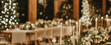 A beautifully decorated winter wedding venue featuring lush greenery, twinkling lights, frosted decor, and soft candlelight, creating a magical and cozy winter wonderland atmosphere.