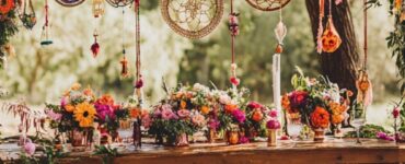 A vibrant boho wedding setup with dreamcatchers, colorful rugs, and lush floral centerpieces that reflect the enduring popularity of the style.
