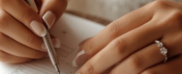 A close-up of a bride's hands holding a wedding planning checklist with a pen, ready to organize a wedding in a short timeframe.
