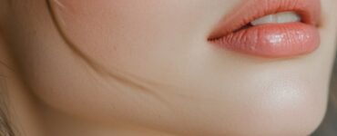 A close-up of a bridesmaid with soft pink eyeshadow, rosy blush, and a nude lip, complementing her elegant dress and glowing skin.