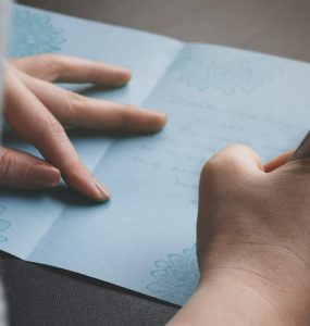 woman writing anniversary card