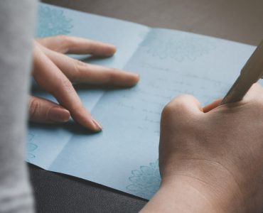 woman writing anniversary card