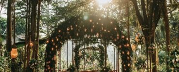 Beautiful outdoor forest wedding venue surrounded by lush greenery, showcasing a natural and immersive setting for a fairytale-like wedding theme.