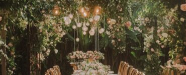 A lush outdoor garden wedding setup with floral decor, featuring a romantic atmosphere surrounded by greenery and flowers.