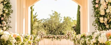 A beautifully decorated outdoor wedding aisle featuring a blend of floral arrangements, greenery, and unique walkway accents, creating a charming and picturesque setting.