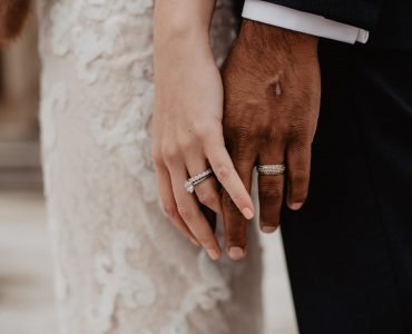 couple holding hands with rings