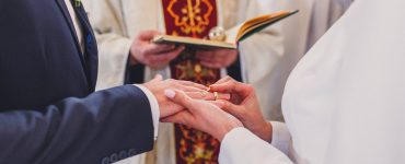 Bride and groom and priest at traditional Polish wedding ceremony