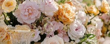 A beautifully decorated wedding table featuring a floral centerpiece, elegant tableware, and pastel-toned linens matching a romantic wedding theme.