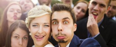 newlyweds taking selfie with their group of friends and making funny faces