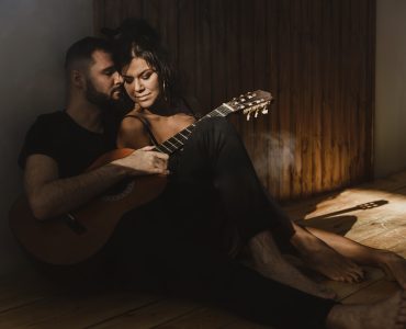 man and woman playing guitar