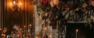 An elegantly decorated wedding venue with Halloween-themed accents, featuring dark floral arrangements, eerie candlelight, and Gothic decor details.