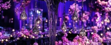 A stunning black and purple wedding setup featuring elegant floral arrangements, dramatic lighting, and sophisticated décor elements.