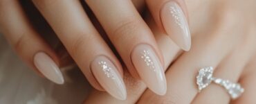 A bride's hands displaying elegant acrylic wedding nails, highlighting the importance of nail design in completing a bridal look.