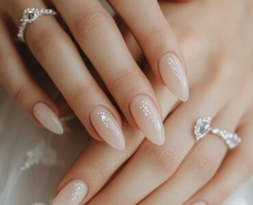 A bride's hands displaying elegant acrylic wedding nails, highlighting the importance of nail design in completing a bridal look.