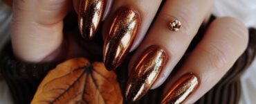Nails painted in shimmering copper polish, reflecting the warm tones of autumn leaves, perfect for a festive fall wedding.