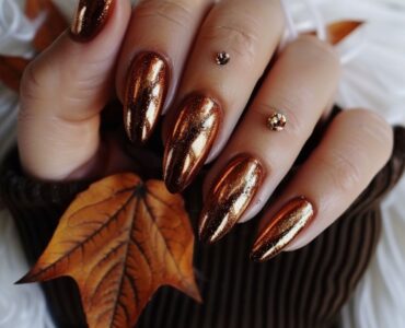 Nails painted in shimmering copper polish, reflecting the warm tones of autumn leaves, perfect for a festive fall wedding.