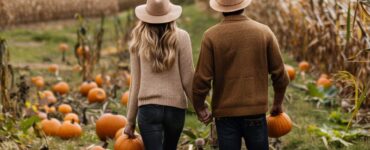 Couple walking through a pumpkin patch, holding hands and picking pumpkins on a crisp fall day. A festive atmosphere with hayrides and corn mazes in the background.