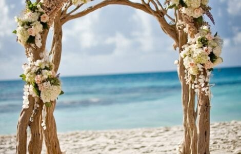 Create a magical and unforgettable beach wedding with driftwood arches, seashell garlands, and tropical flowers that capture the ocean's beauty and serenity.