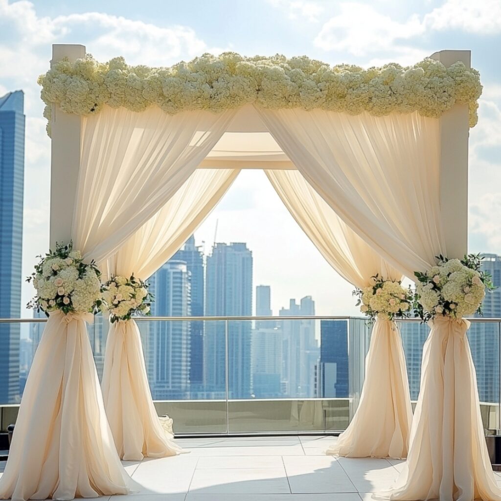 An airy canopy or delicate draping in soft fabrics adds a dreamy, romantic touch to a rooftop wedding, framing the city skyline beautifully.