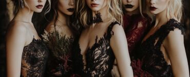 A group of bridesmaids showcasing Halloween bridesmaid dresses in dark colors and luxurious fabrics, adding a stylish, eerie ambiance to the wedding celebration with a perfect blend of mystery and elegance.