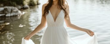 A bride wearing a flowing lakefront wedding dress, blending vintage charm, modern simplicity, or a romantic silhouette, complementing the natural beauty of the waterfront venue.