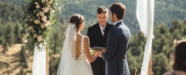A couple exchanging vows with a breathtaking mountain view as the backdrop, celebrating their love in a stunning natural setting.