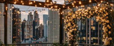 A magical rooftop wedding setup showcasing string lights, floral arches, and modern lounge areas, blending urban charm with sophistication and breathtaking views.