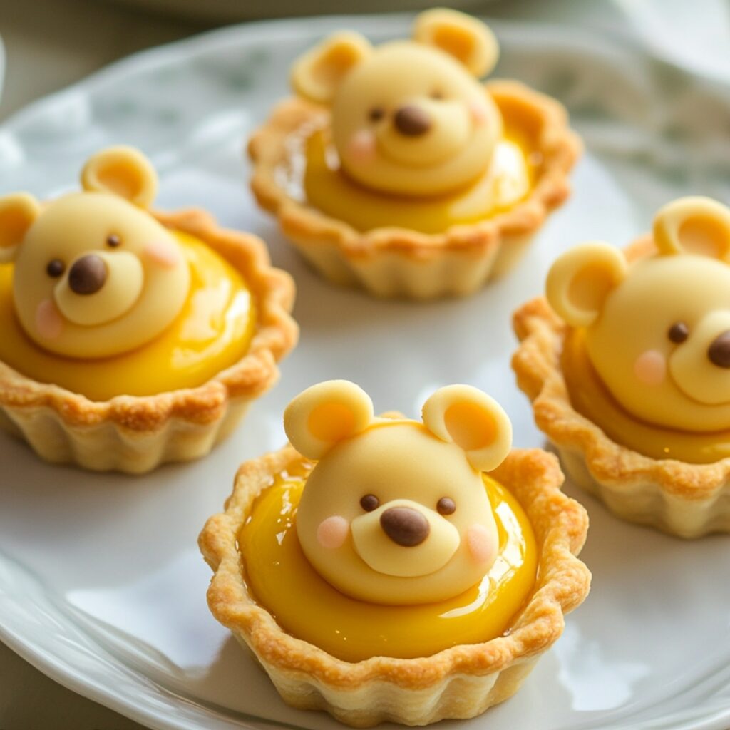 Pastry tarts filled with a sweet honey custard, topped with fondant "honey drips," resembling Winnie the Pooh’s honey pots for a whimsical dessert.