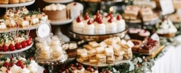 An elegant Christmas wedding dessert table featuring a variety of festive treats like fruitcake, peppermint mousse cups, and gingerbread, perfectly capturing the holiday spirit.