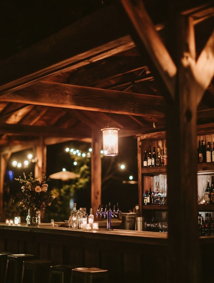 A rustic barn venue with exposed wooden beams, soft lighting, and vintage décor, creating an intimate and romantic atmosphere perfect for an October wedding.