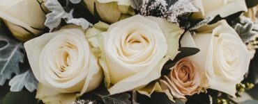 Elegant winter wedding bouquet with white roses and eucalyptus, surrounded by frosted accents, highlighting the enchanting charm of winter weddings.