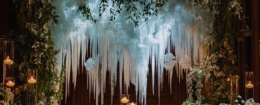 Elegant January wedding ceremony with a backdrop inspired by winter elements, featuring icy designs, cozy candlelight, and lush greenery for a warm and enchanting ambiance.