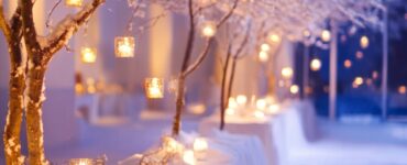 Close-up of a winter wedding venue decorated with snow-covered branches, soft lighting, and cozy details, evoking a warm, romantic January wedding atmosphere.
