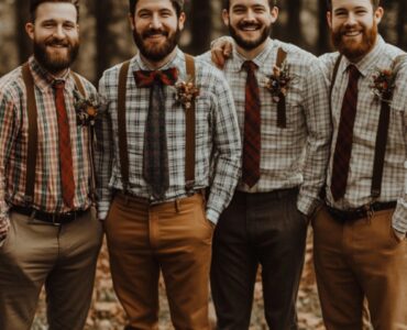 Rustic groomsmen standing outdoors in nature, dressed in a variety of outfits like suspenders, plaid shirts, and earth-toned suits, showcasing vintage-inspired rustic wedding attire.