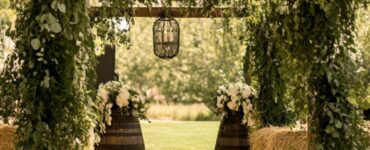 An enchanting rustic wedding setup featuring natural elements, vintage charm, and heartfelt simplicity, including greenery-draped wooden arches and hay bale walls.