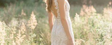 A bride in a rustic outdoor wedding setting wearing a lace wedding dress, surrounded by nature, with a soft, romantic glow.