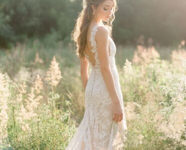 A bride in a rustic outdoor wedding setting wearing a lace wedding dress, surrounded by nature, with a soft, romantic glow.