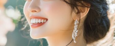 A rustic bride smiling outdoors, showcasing natural and radiant makeup with soft, earthy tones that blend seamlessly with her woodland wedding setting.