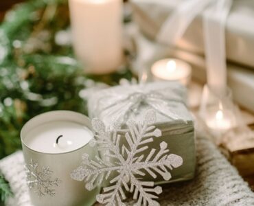 Elegant winter wedding setup featuring snowflake ornaments, cozy blankets, and candle favors, showcasing thoughtful and charming winter-themed guest gifts.