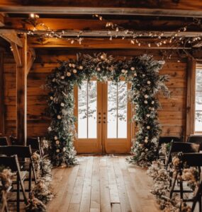 A cozy winter wedding ceremony setup featuring a flower arch decorated with winter-inspired flowers and greenery, creating a magical, seasonal backdrop for an intimate ceremony.