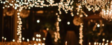 Warmly lit winter wedding venue featuring soft lighting from candles, fairy lights, and chandeliers, creating an enchanting and romantic ambiance.