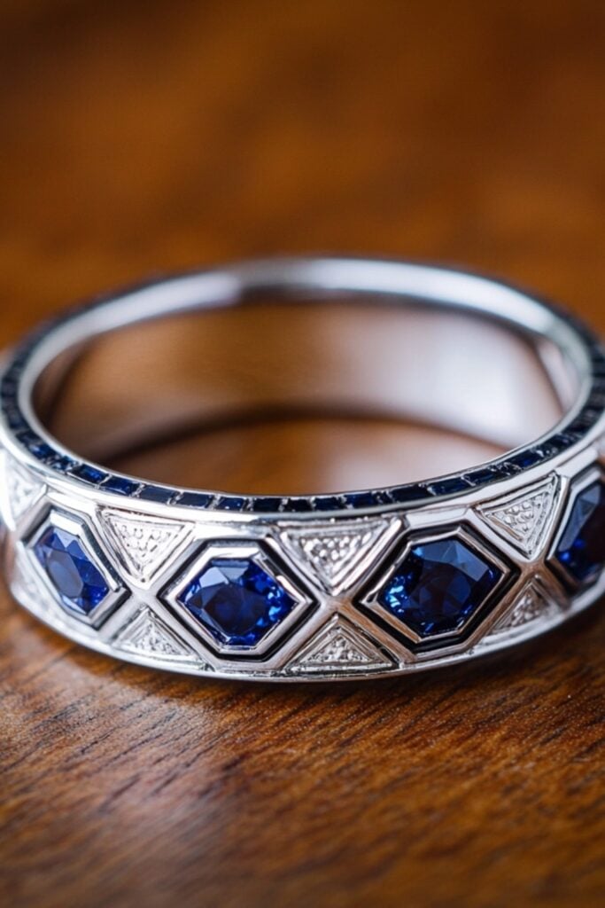 Bold and symmetrical Art Deco wedding band with geometric designs and colorful gemstones, inspired by 1920s elegance.