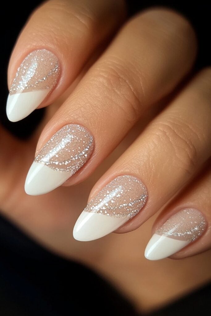 Close-up of hands with a classic French manicure featuring white tips and a glossy finish, accented with a thin glitter line for added elegance.