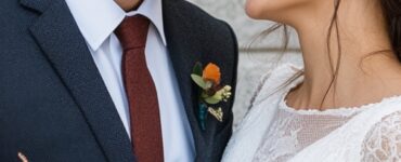 A newlywed couple shares a joyful moment on the courthouse steps, the bride holding a bouquet while the groom lovingly looks at her, highlighting simplicity and timeless style.
