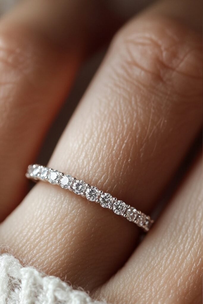 An eternity band featuring a continuous line of small round diamonds set in a delicate white gold band, symbolizing everlasting love.