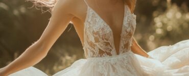 Image of a bride twirling in a delicate, ethereal wedding dress with layers of tulle or lace, radiating grace and elegance, set against a magical, natural backdrop.