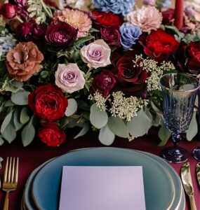 A romantic February wedding setup featuring a color palette swatch with vibrant red, serene blue, elegant purple, and lush green hues, symbolizing love and charm.