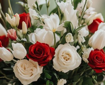 A romantic February wedding scene featuring a beautifully arranged floral centerpiece with red roses, white tulips, and soft greenery, symbolizing love and elegance.